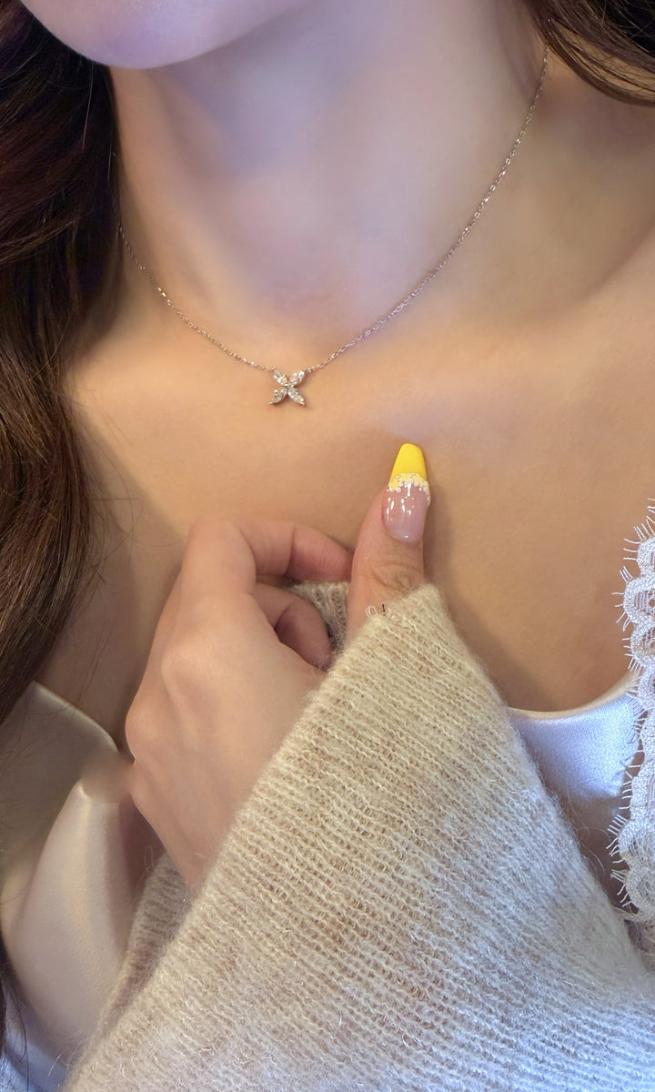 quのネックレスを身につけた女性の首元
